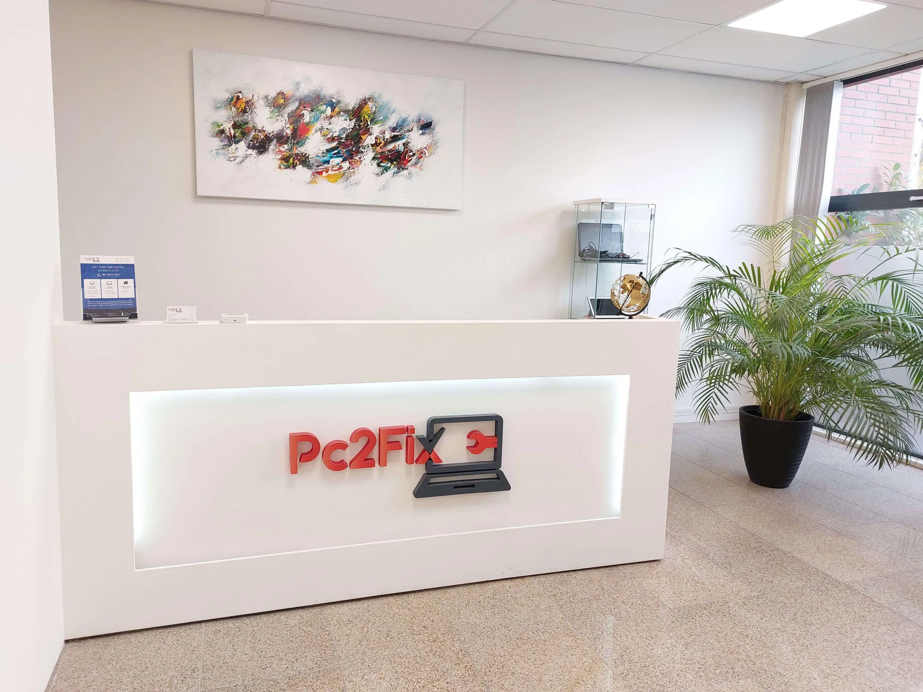 Computer repair shop front desk with the red PC2Fix logo at PC2Fix Hengelo, Zaagstraat 15.